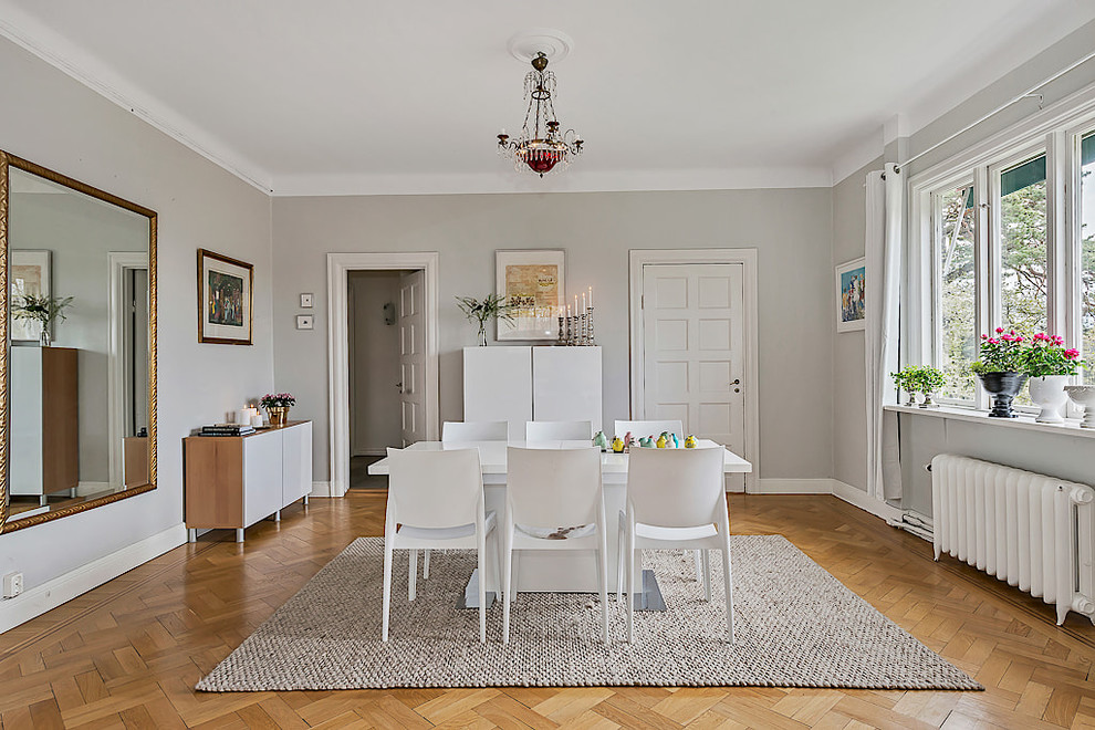 Inspiration for a scandi enclosed dining room in Stockholm with grey walls, light hardwood flooring, no fireplace and beige floors.