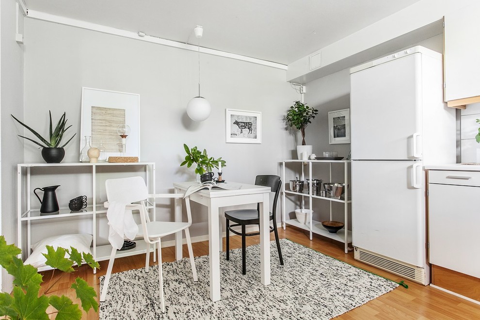 На фото: большая кухня-столовая в скандинавском стиле с серыми стенами и светлым паркетным полом с