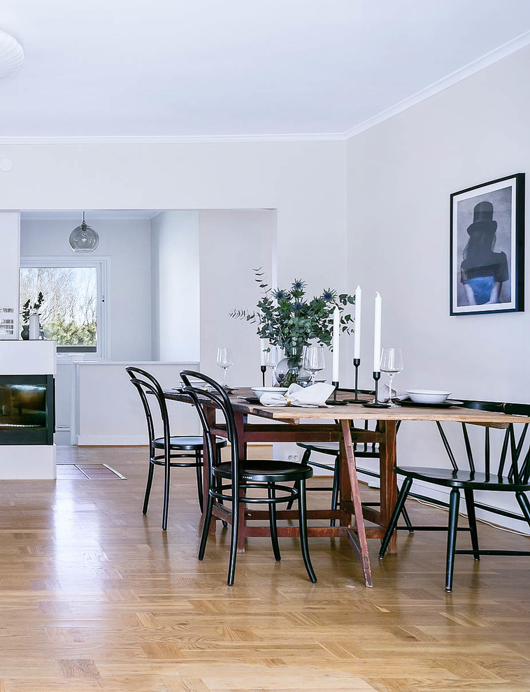 Large scandinavian open plan dining room in Gothenburg with white walls, light hardwood flooring and beige floors.