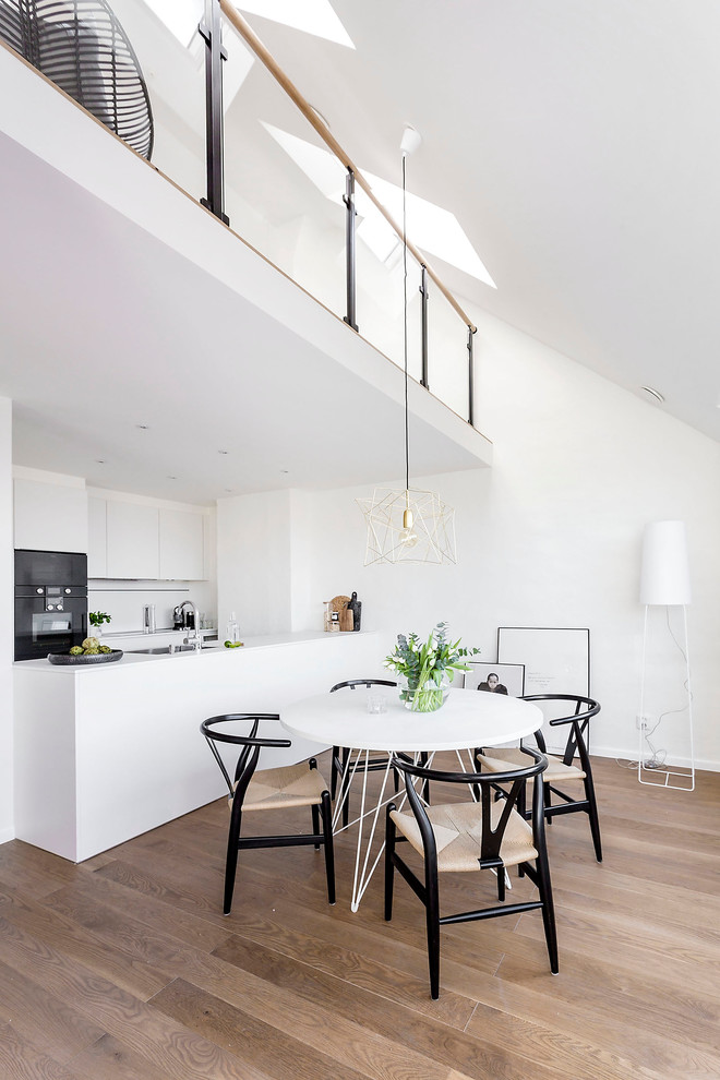 Foto på ett mellanstort minimalistiskt kök med matplats, med vita väggar och ljust trägolv