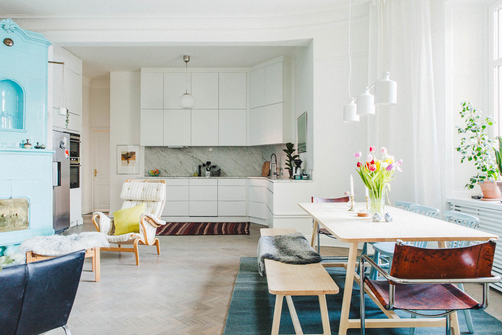 Idee per una sala da pranzo aperta verso il soggiorno nordica di medie dimensioni con parquet chiaro e pareti bianche