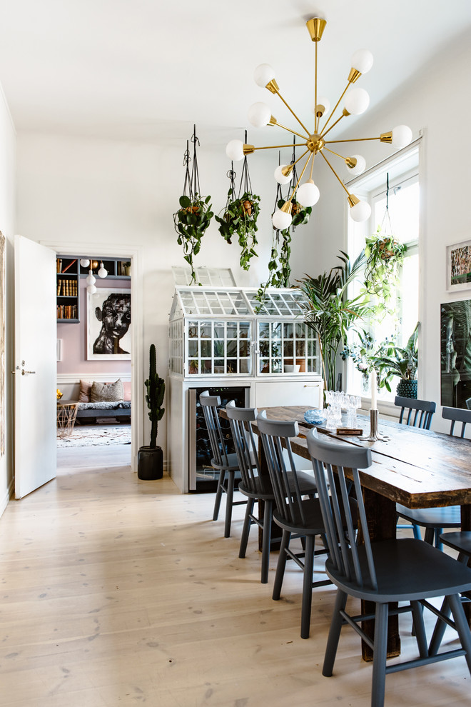 Immagine di una sala da pranzo bohémian chiusa e di medie dimensioni con pareti bianche, parquet chiaro, pavimento beige e nessun camino