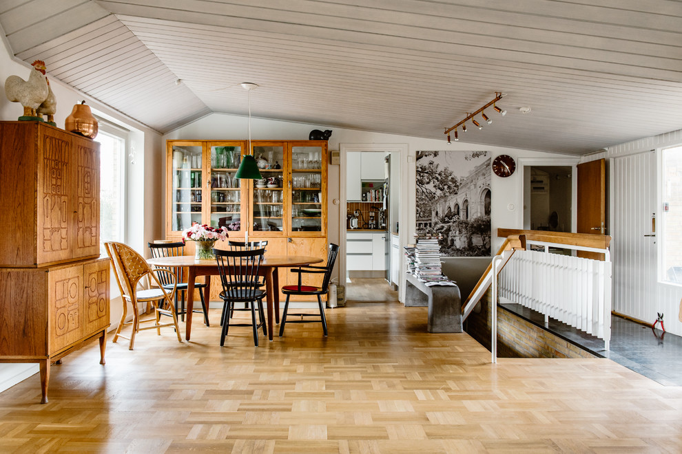 Photo of a medium sized scandinavian dining room in Stockholm with white walls, medium hardwood flooring and brown floors.