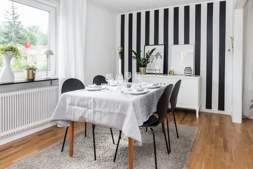 Réalisation d'une salle à manger nordique de taille moyenne avec un mur multicolore, un sol en bois brun et aucune cheminée.