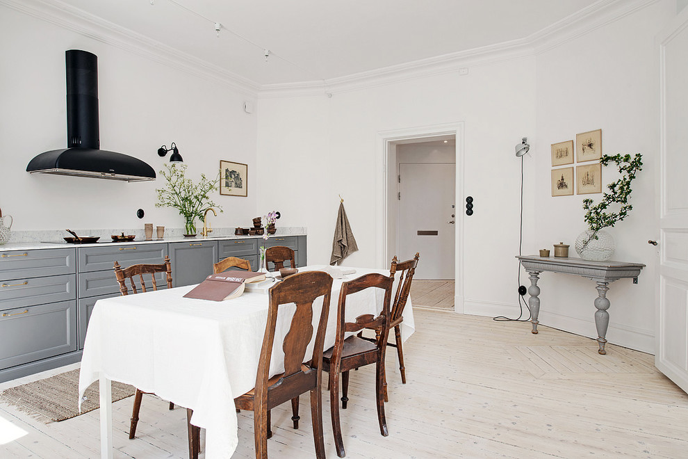 Inspiration för ett mellanstort minimalistiskt kök med matplats, med vita väggar och ljust trägolv