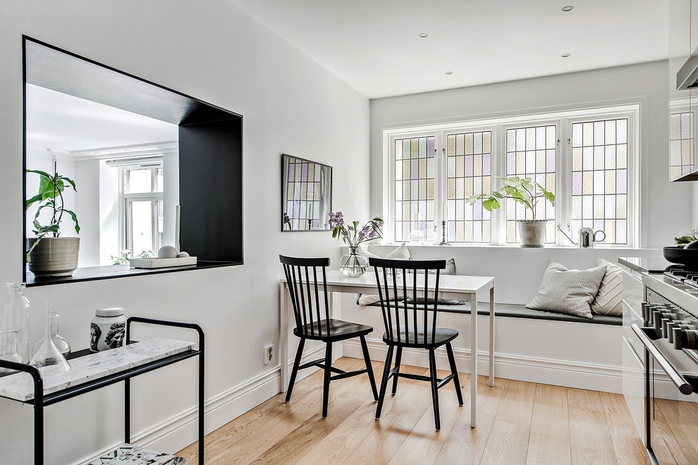 Foto di una piccola sala da pranzo aperta verso la cucina scandinava con pareti bianche, pavimento beige e parquet chiaro
