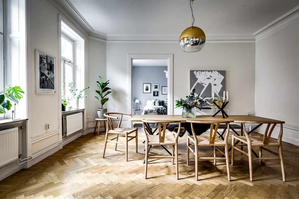 Example of a large danish medium tone wood floor and beige floor dining room design in Stockholm with beige walls
