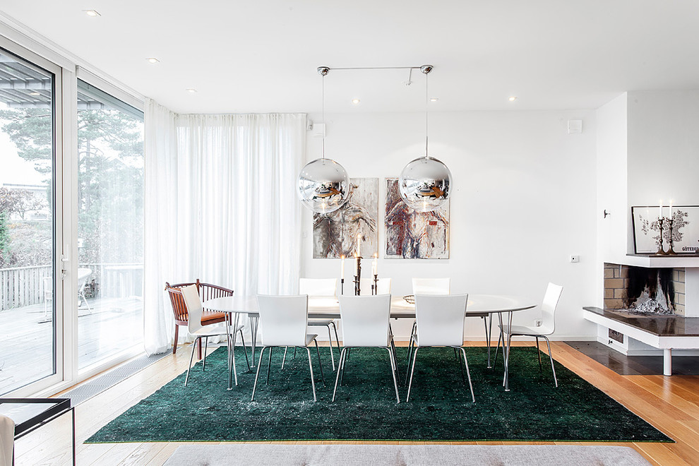 Esempio di una grande sala da pranzo minimal con pareti bianche, pavimento in legno massello medio e pavimento marrone