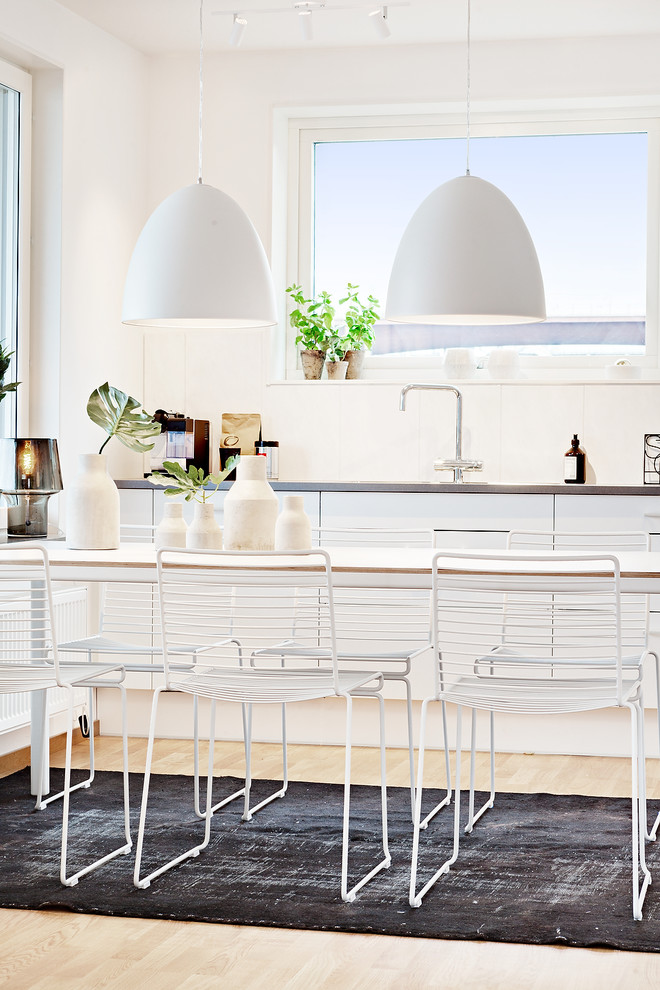 Inspiration för ett mellanstort minimalistiskt kök med matplats, med vita väggar, ljust trägolv och beiget golv