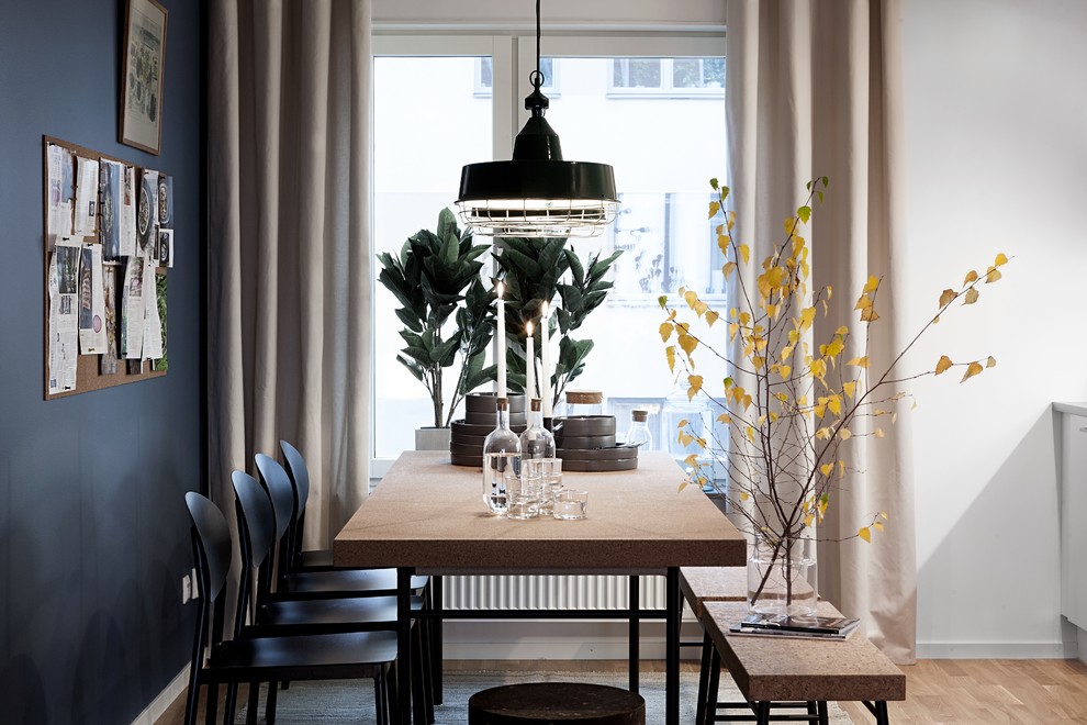 Foto di una sala da pranzo aperta verso la cucina minimal con pareti bianche, parquet chiaro e pavimento marrone