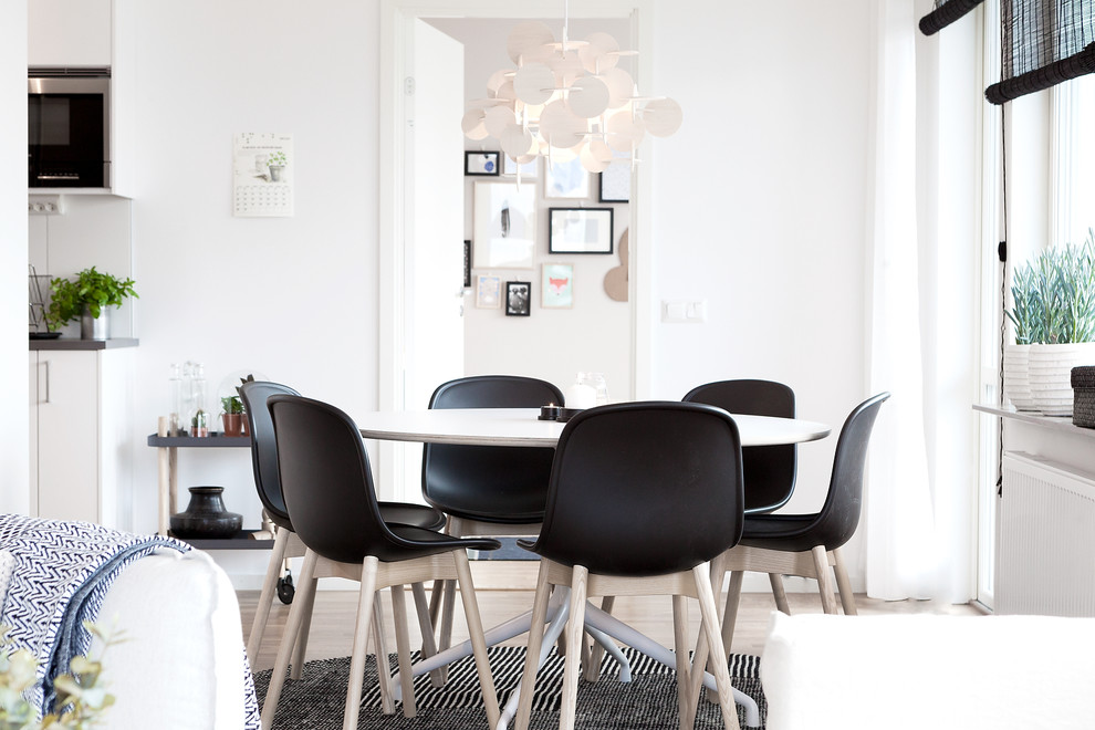 Idee per una sala da pranzo aperta verso la cucina scandinava con pareti bianche, parquet chiaro e pavimento marrone