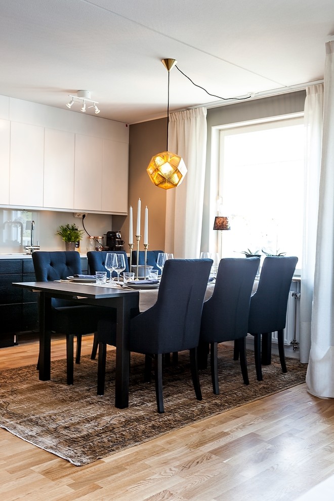 Cette image montre une salle à manger ouverte sur la cuisine design de taille moyenne avec un mur beige, un sol en bois brun et un sol marron.