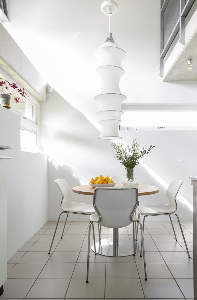 Diseño de comedor contemporáneo con paredes blancas y suelo blanco