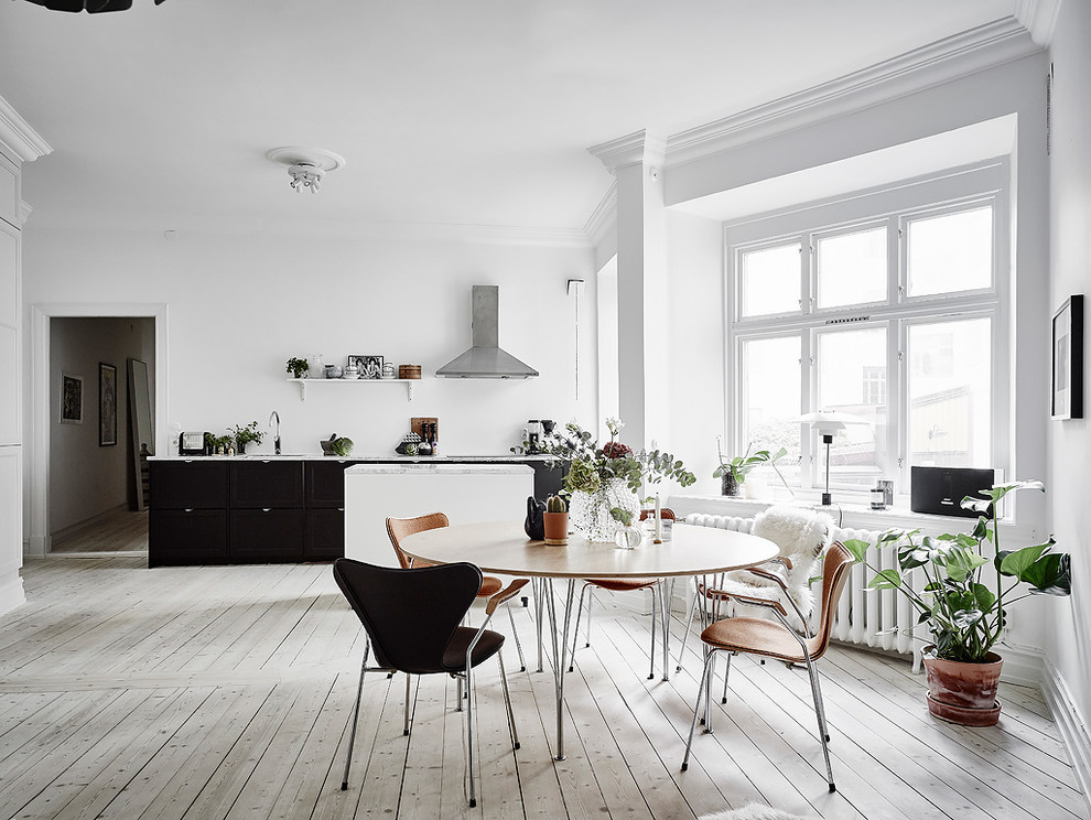 Foto de comedor nórdico de tamaño medio sin chimenea con paredes blancas y suelo de madera clara