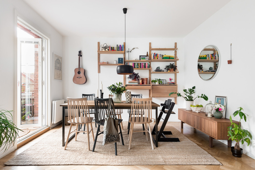 Cette photo montre une salle à manger scandinave de taille moyenne avec un mur blanc, aucune cheminée, un sol marron, parquet clair et éclairage.