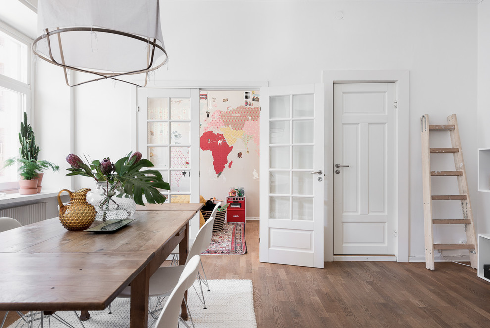 Photo of a large scandi open plan dining room in Gothenburg with white walls, medium hardwood flooring and no fireplace.