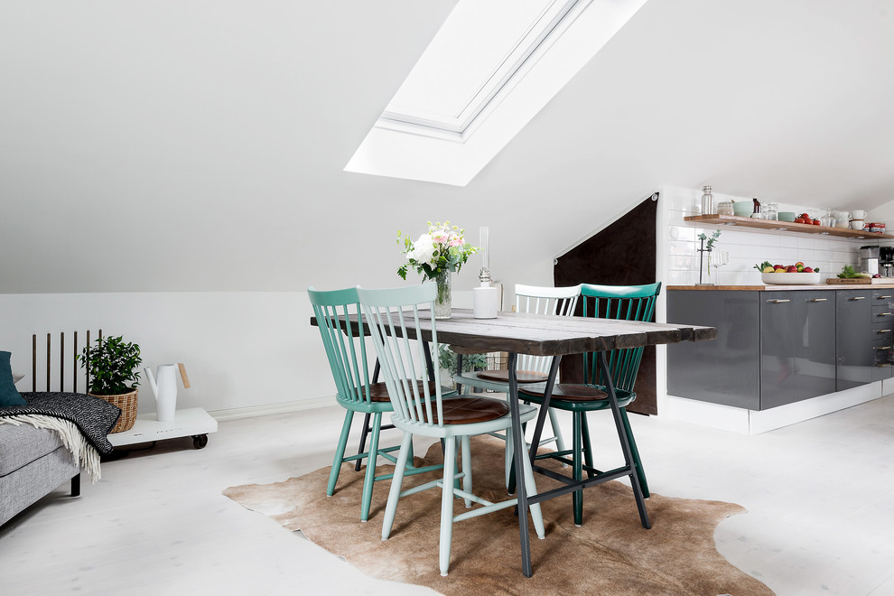 Esempio di una sala da pranzo aperta verso il soggiorno scandinava di medie dimensioni con pareti bianche e parquet chiaro