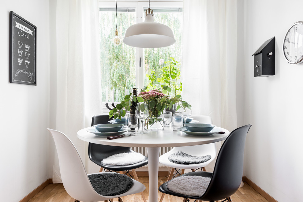 Idee per una piccola sala da pranzo aperta verso il soggiorno scandinava con pareti bianche e pavimento in legno massello medio