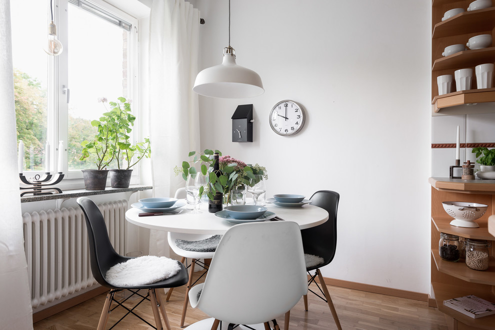 Idées déco pour une petite salle à manger ouverte sur le salon scandinave avec un mur blanc et un sol en bois brun.