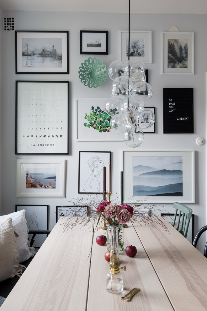 Ispirazione per una sala da pranzo aperta verso il soggiorno nordica di medie dimensioni con parquet chiaro e pavimento bianco