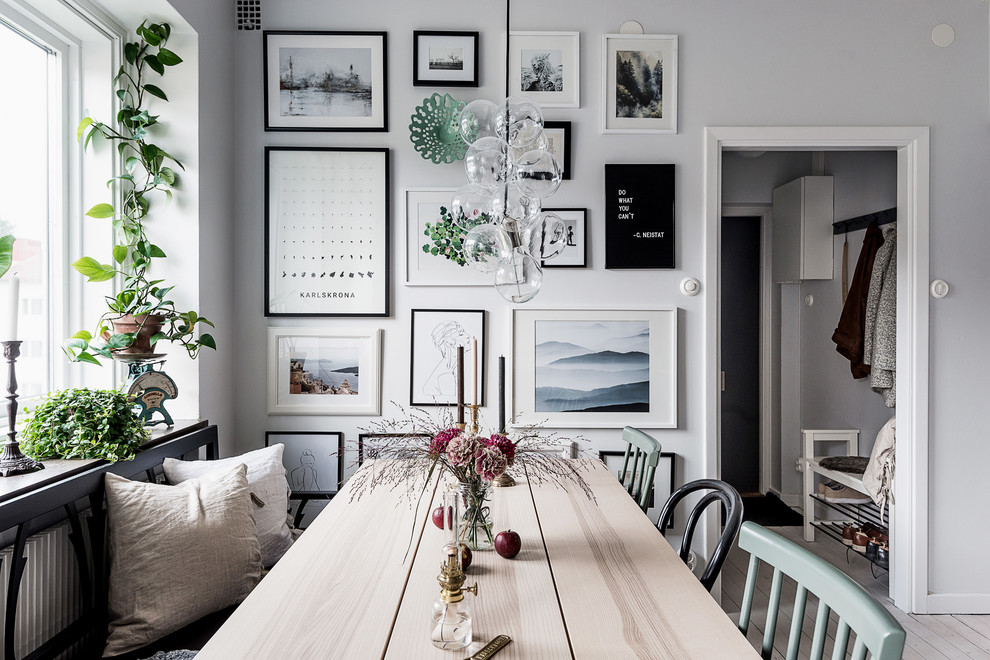Foto di una sala da pranzo aperta verso il soggiorno scandinava di medie dimensioni con parquet chiaro e pavimento bianco