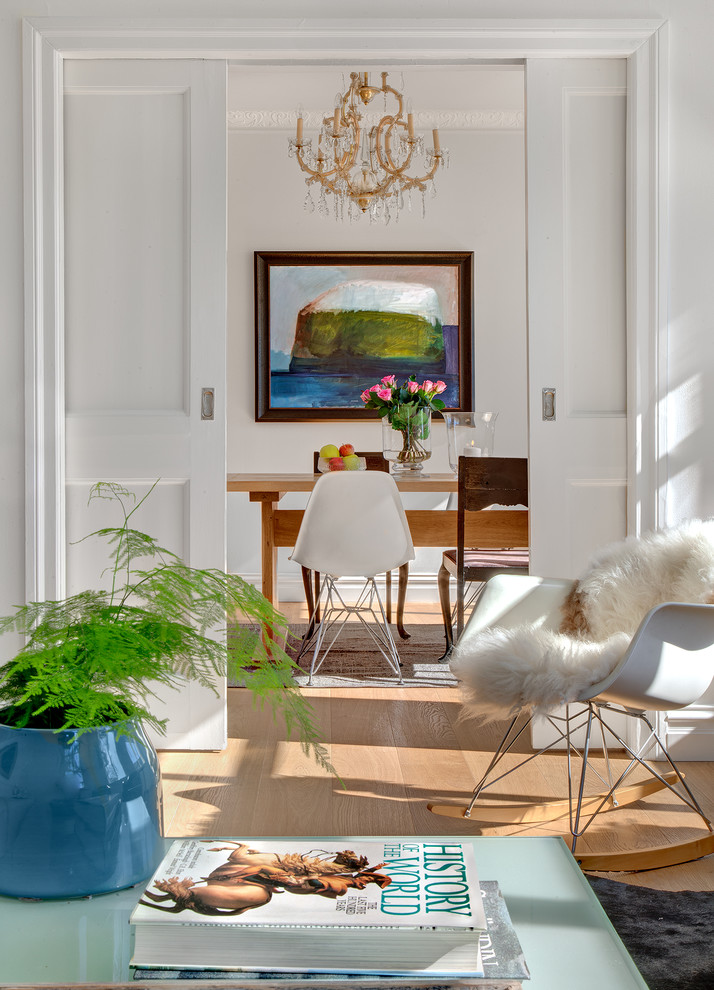 Transitional light wood floor and brown floor enclosed dining room photo in Gothenburg with white walls