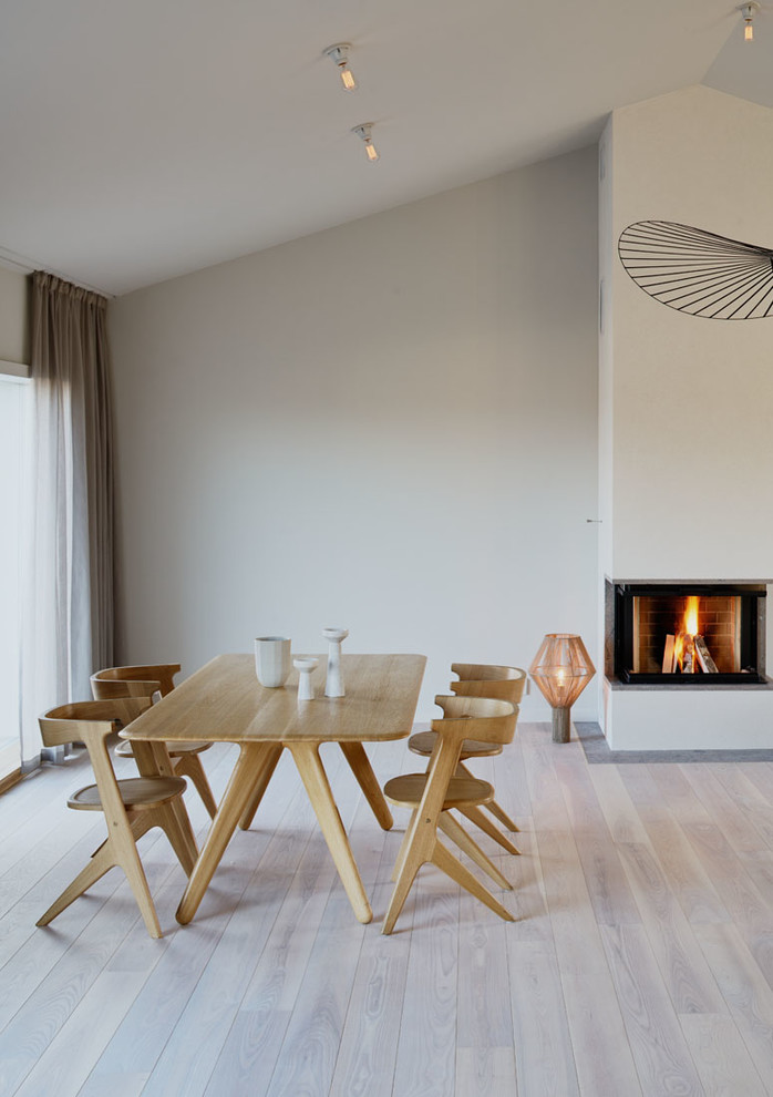 Diseño de comedor escandinavo grande abierto con paredes blancas y suelo de madera clara