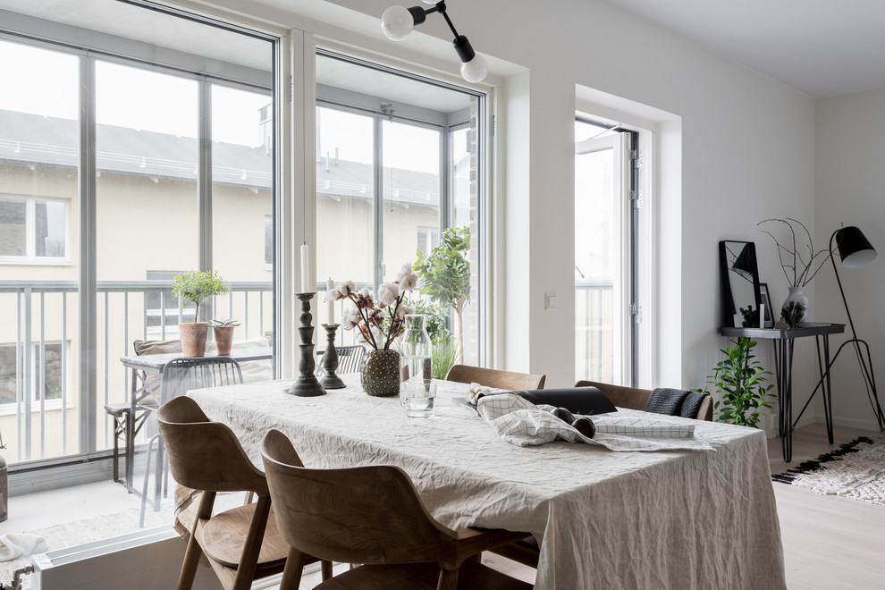 На фото: гостиная-столовая среднего размера в скандинавском стиле с белыми стенами и светлым паркетным полом с