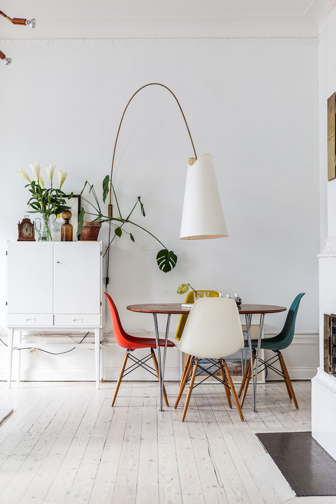 Medium sized scandinavian enclosed dining room in Stockholm with white walls, painted wood flooring and no fireplace.