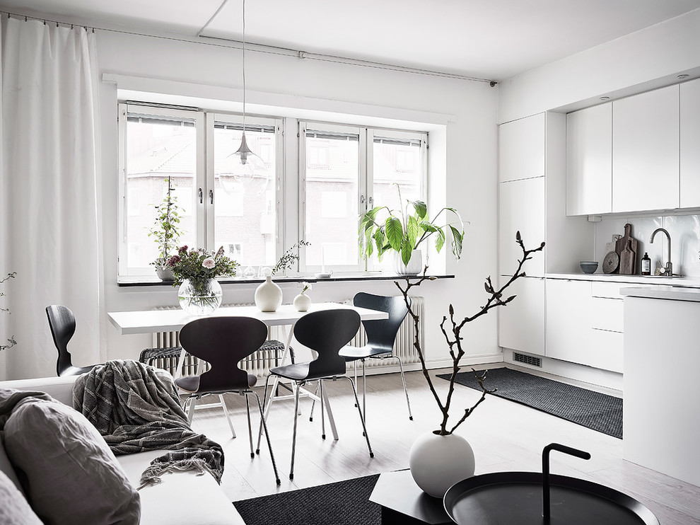 Пример оригинального дизайна: гостиная-столовая в скандинавском стиле с белыми стенами, светлым паркетным полом и серым полом