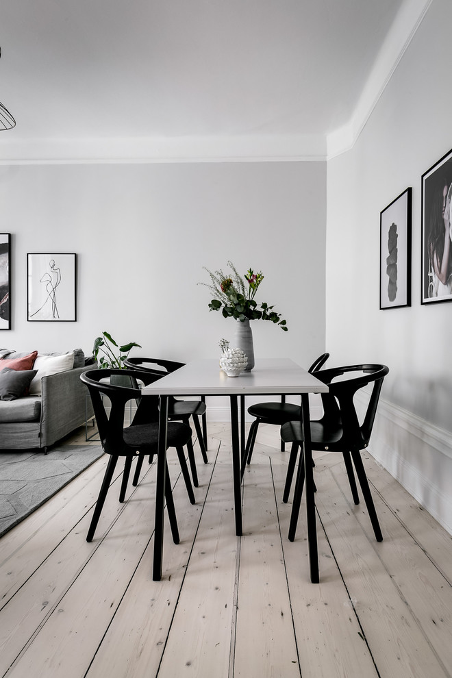 Cette photo montre une salle à manger scandinave de taille moyenne avec un mur blanc, parquet clair et un sol beige.