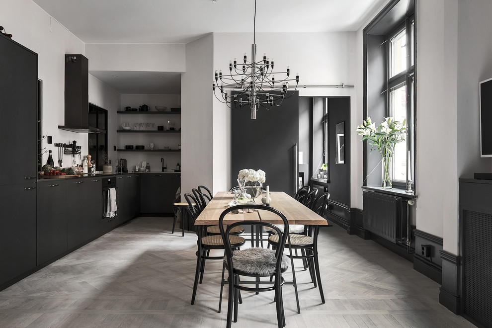 Idee per una sala da pranzo aperta verso la cucina scandinava con pareti bianche, parquet chiaro, nessun camino e pavimento grigio