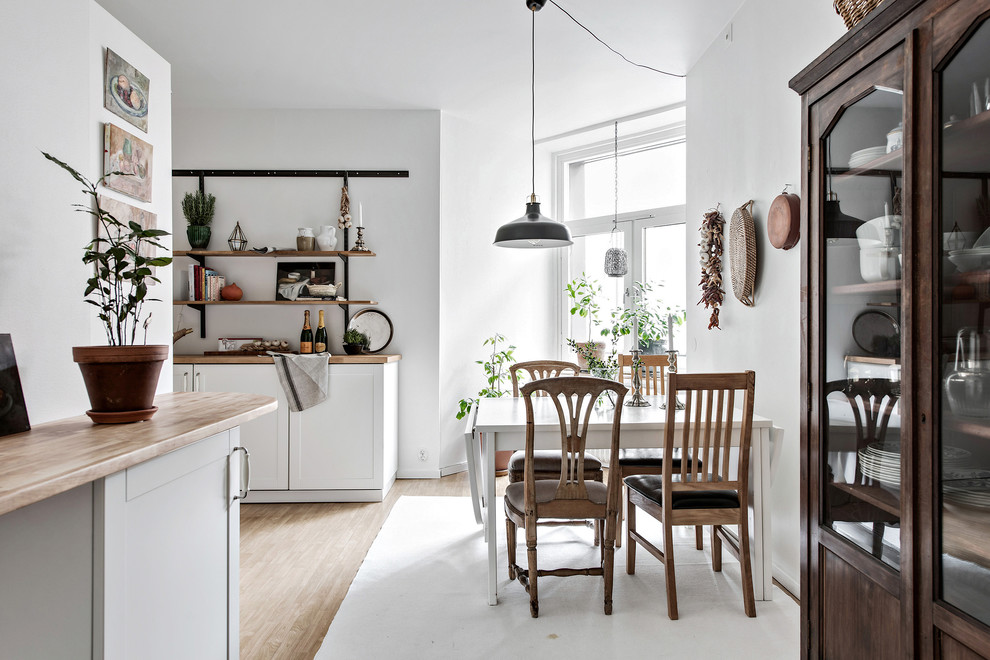 Mittelgroße Skandinavische Wohnküche ohne Kamin mit weißer Wandfarbe, hellem Holzboden und beigem Boden in Göteborg