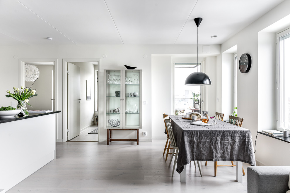 Idee per una sala da pranzo aperta verso la cucina nordica di medie dimensioni con pareti bianche e pavimento in legno verniciato
