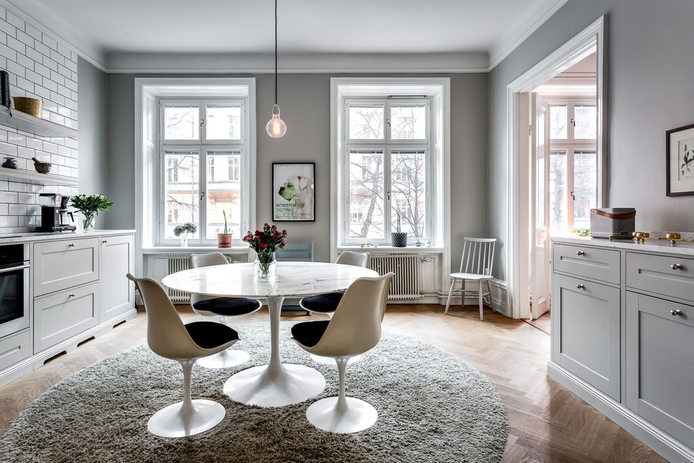 This is an example of a medium sized scandi kitchen/dining room in Stockholm with grey walls and medium hardwood flooring.