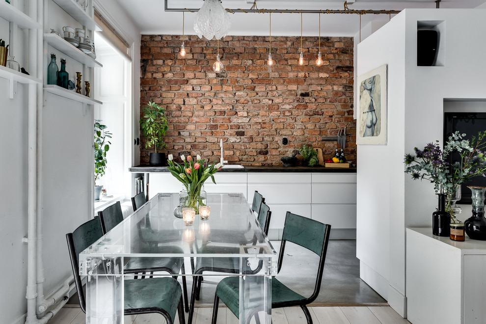 Immagine di una grande sala da pranzo aperta verso la cucina scandinava con pareti bianche e pavimento in cemento