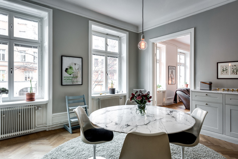 Idee per una sala da pranzo aperta verso la cucina scandinava di medie dimensioni con pareti grigie e pavimento in legno massello medio