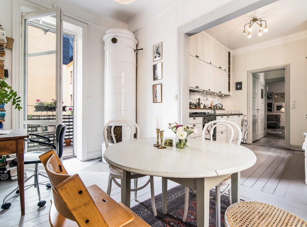 Mittelgroße Nordische Wohnküche mit weißer Wandfarbe, gebeiztem Holzboden und Kaminofen in Stockholm
