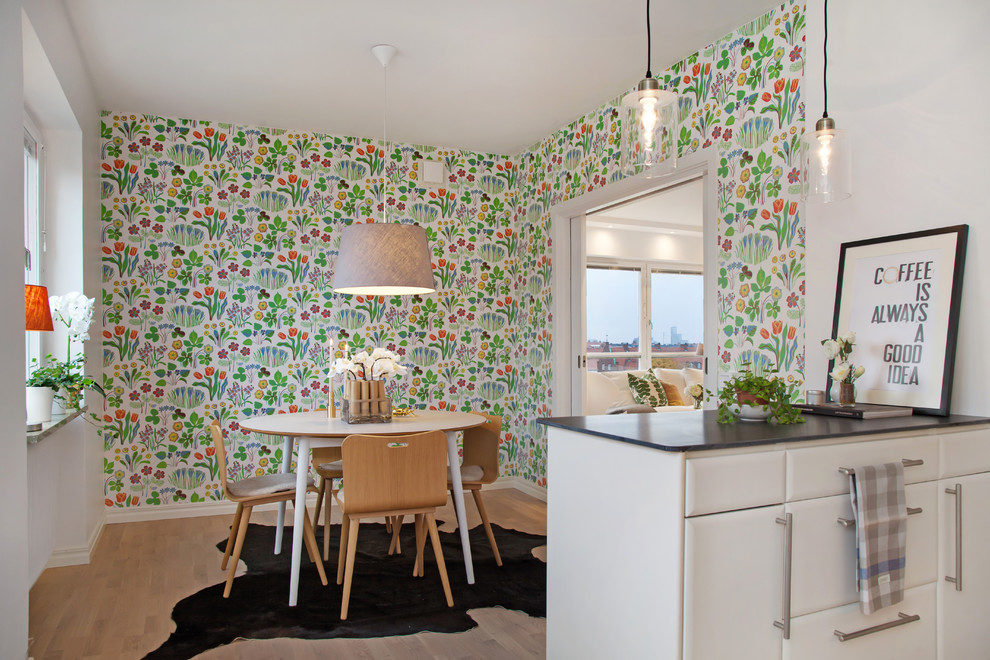 Foto di una sala da pranzo aperta verso la cucina moderna di medie dimensioni con pareti multicolore e parquet chiaro
