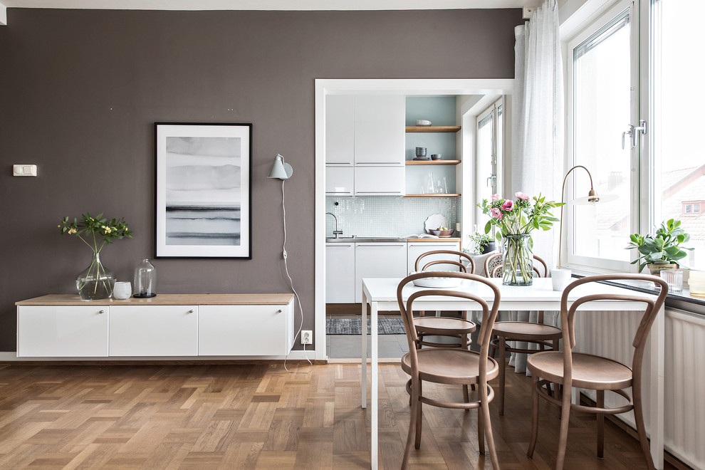 Nordisches Esszimmer ohne Kamin mit brauner Wandfarbe, braunem Holzboden und beigem Boden in Göteborg
