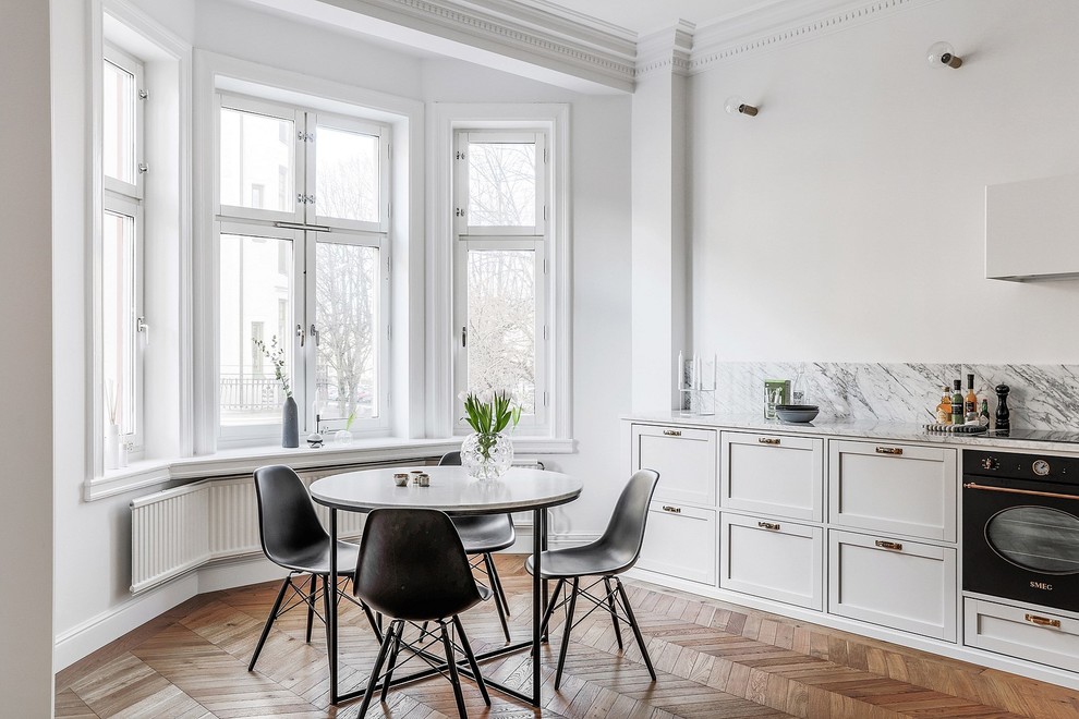 Idee per una grande sala da pranzo aperta verso la cucina scandinava con pavimento in legno massello medio, pareti bianche e pavimento marrone