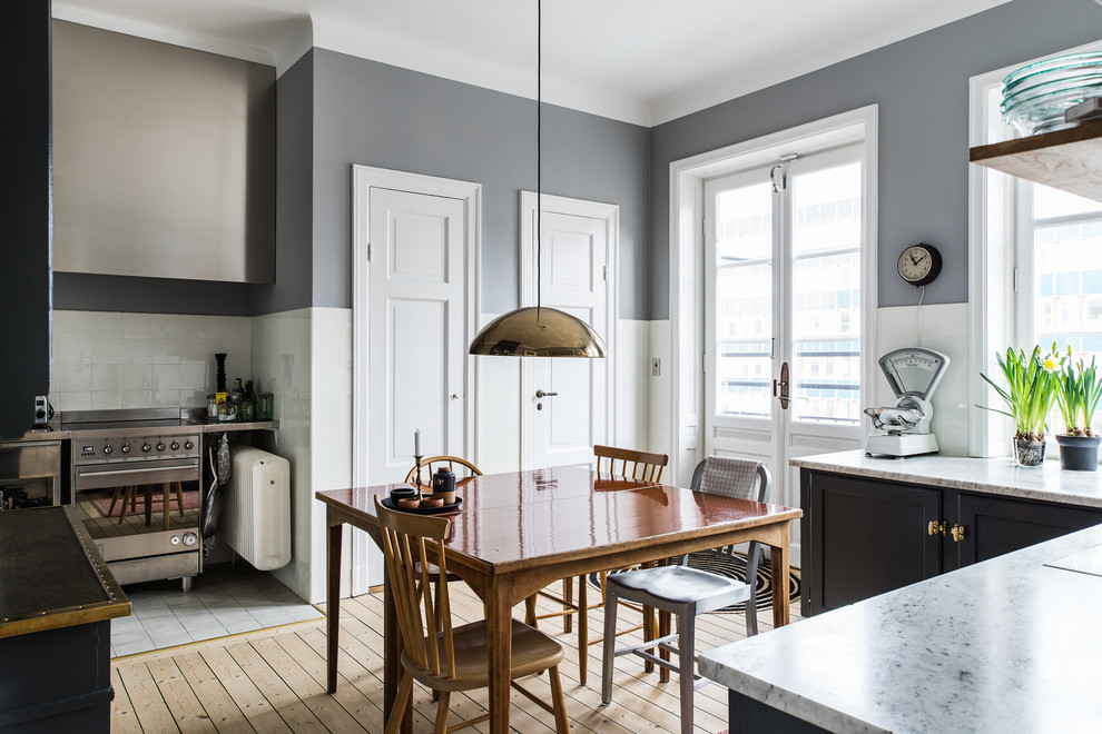 На фото: кухня-столовая среднего размера в скандинавском стиле с серыми стенами и светлым паркетным полом без камина с