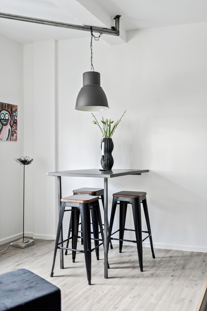 Small industrial open plan dining room in Gothenburg with white walls, light hardwood flooring and grey floors.