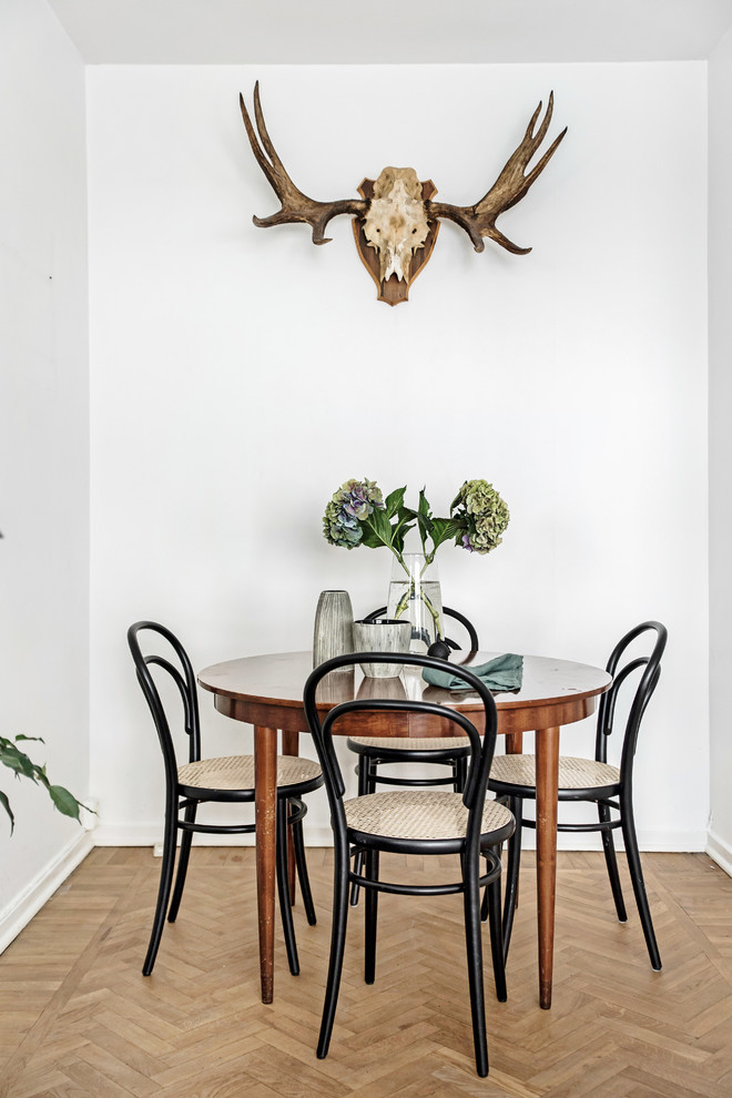 Cette photo montre une petite salle à manger scandinave fermée avec un mur blanc, un sol en bois brun et un sol beige.