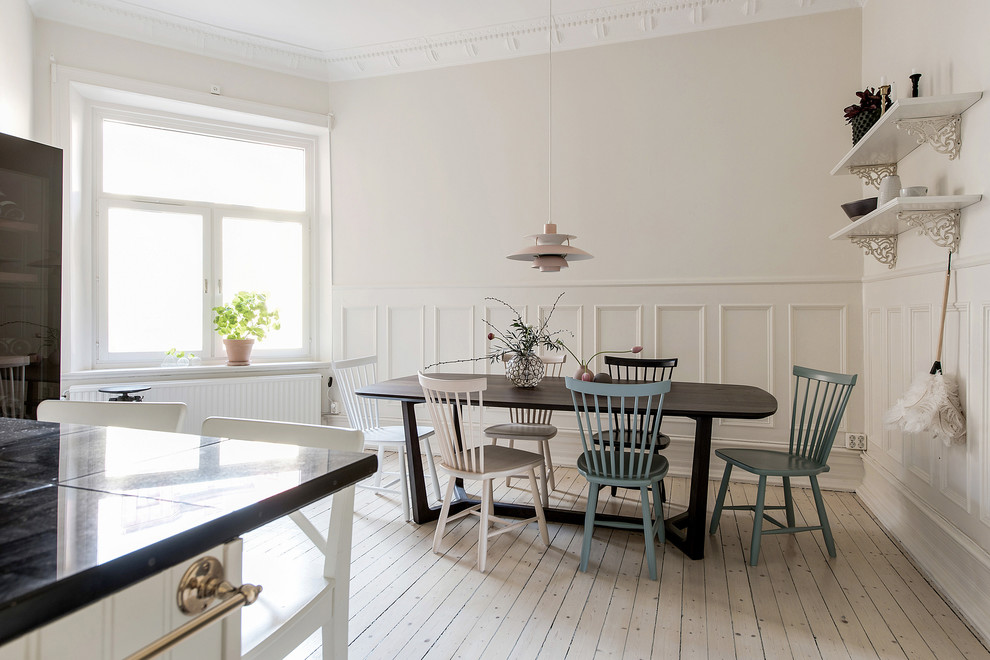Scandi kitchen/dining room in Gothenburg with beige walls, light hardwood flooring and beige floors.