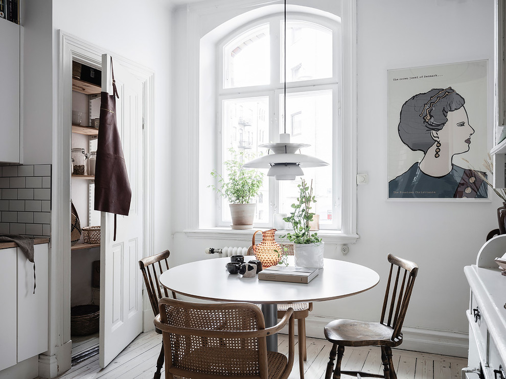 Esempio di una piccola sala da pranzo aperta verso la cucina scandinava con pareti bianche, nessun camino, pavimento in legno verniciato e pavimento bianco