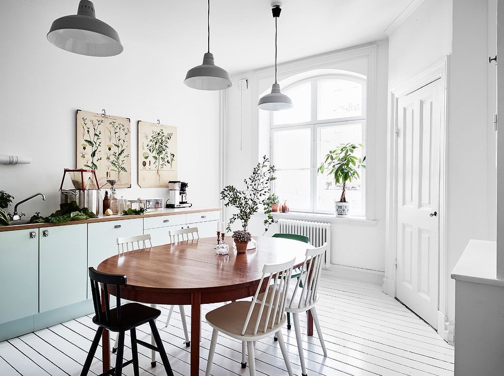 Idée de décoration pour une salle à manger ouverte sur la cuisine nordique de taille moyenne avec un mur blanc, parquet peint et un sol blanc.