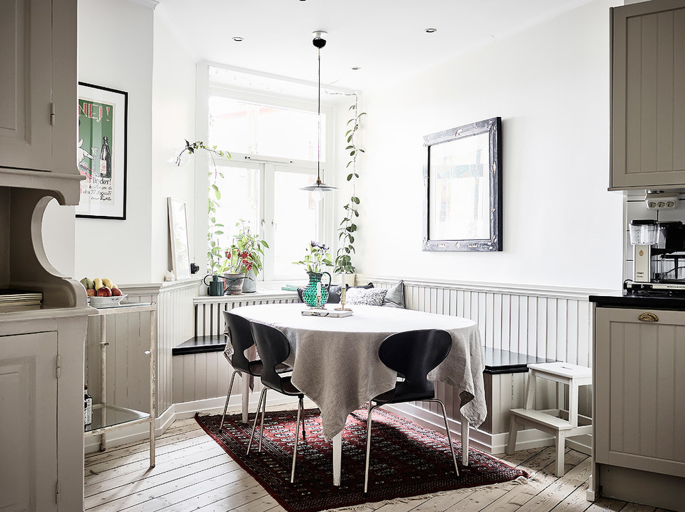 Inredning av ett minimalistiskt kök med matplats, med vita väggar, ljust trägolv och beiget golv