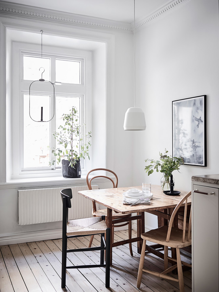 Idées déco pour une salle à manger scandinave avec un mur blanc et un sol marron.