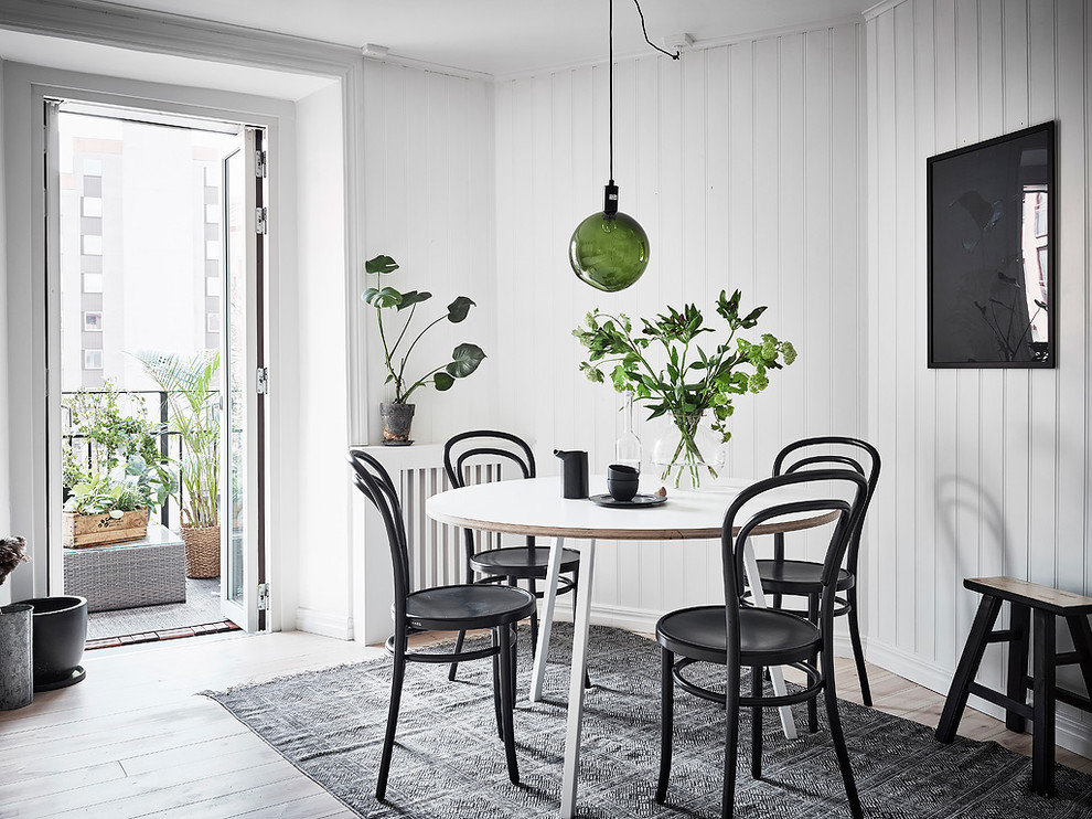 Bild på ett nordiskt kök med matplats, med vita väggar, ljust trägolv och vitt golv